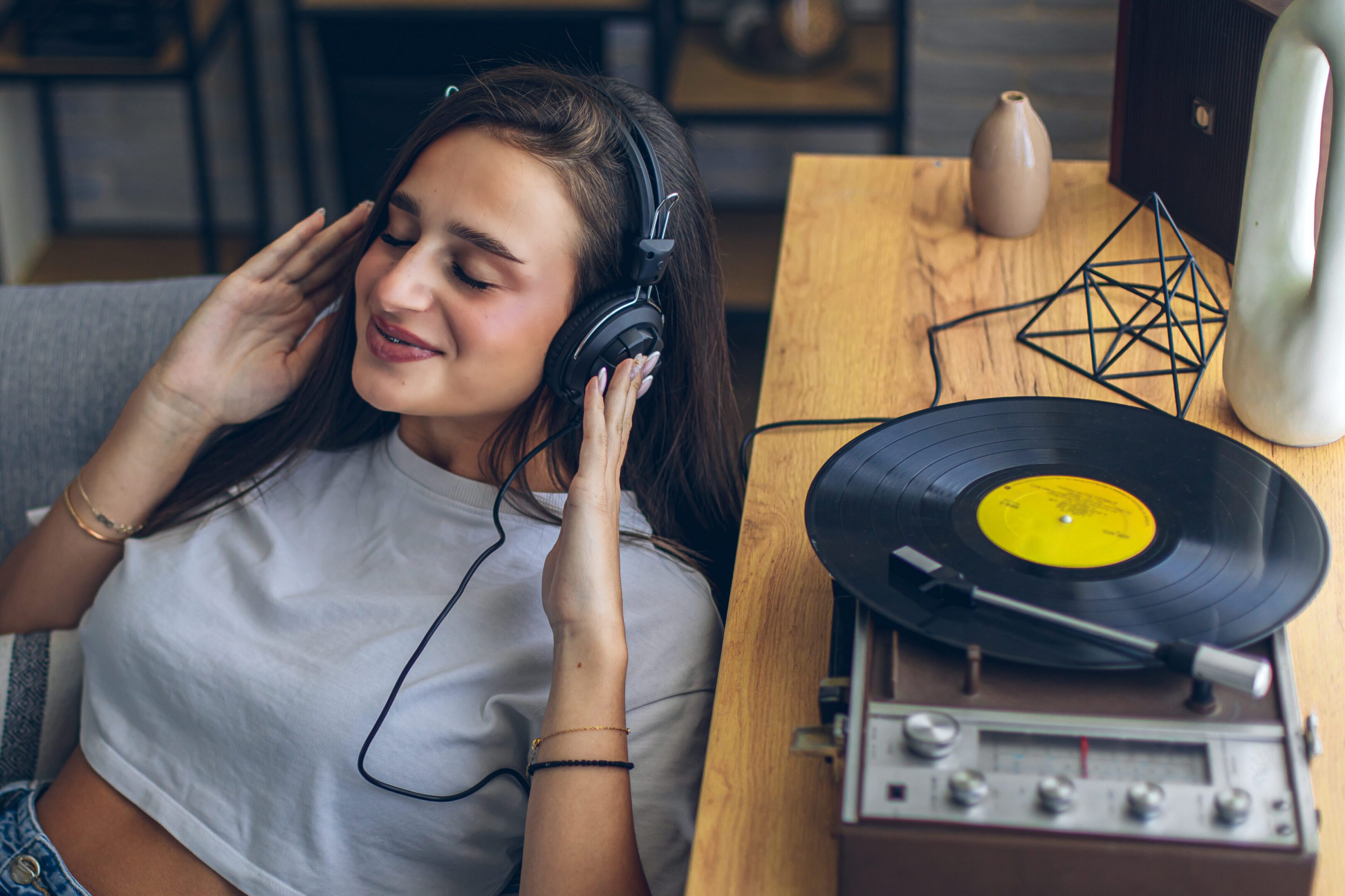Woman listening to music on headphones, smiling.